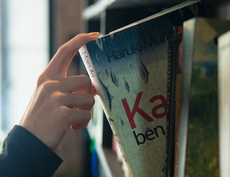 person pulling book off shelf
