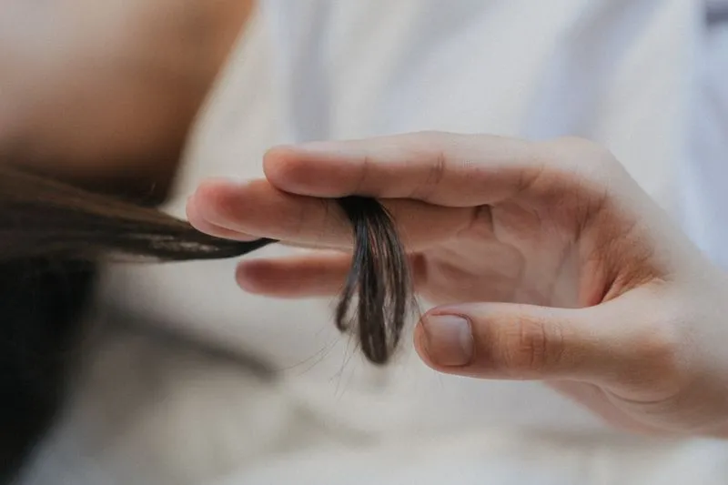 woman holding out hair between fingers