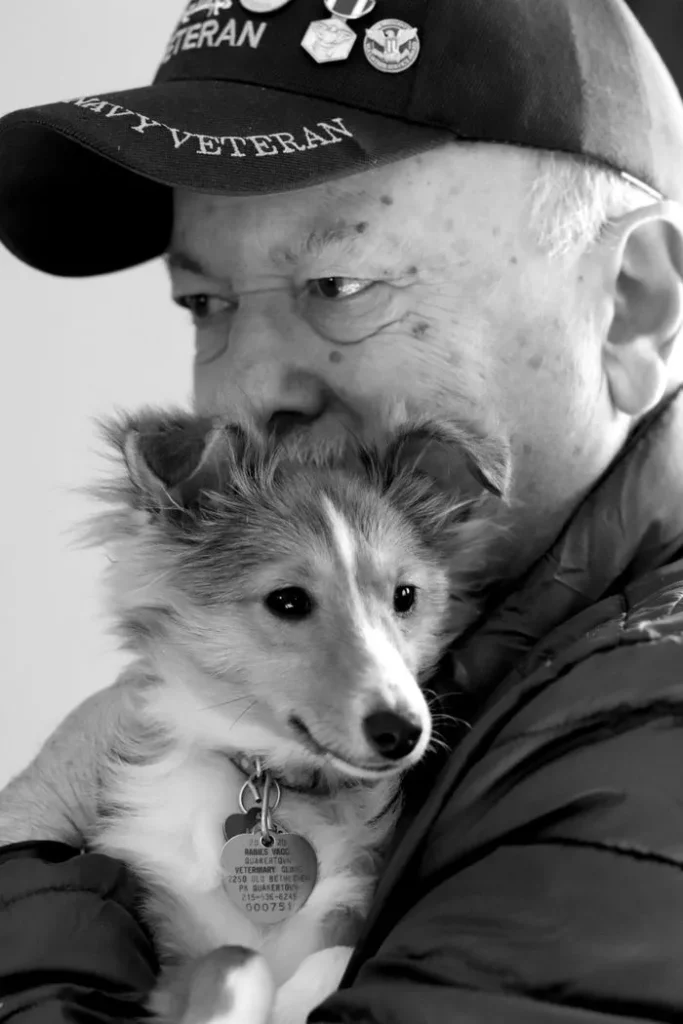 veteran man hugging small dog