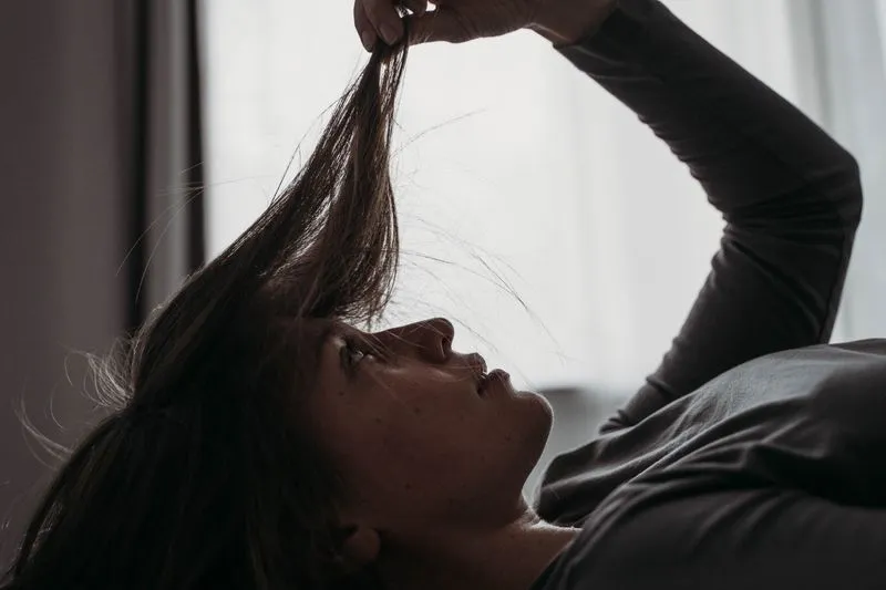 woman holding up hair