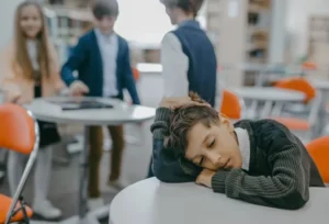 boy in school with head on desk