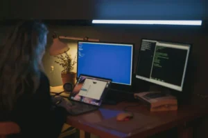 person using blue light on computer screen at night