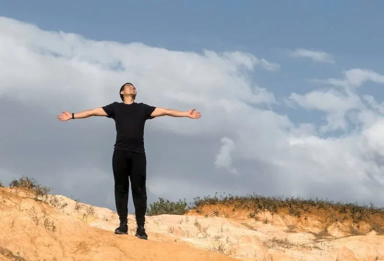 man standing with arms wide open