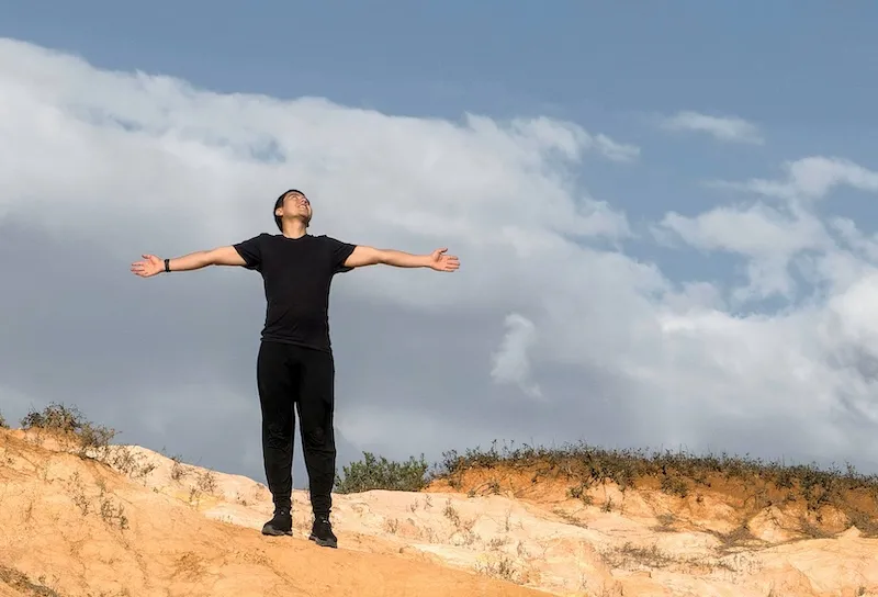 man standing with arms wide open