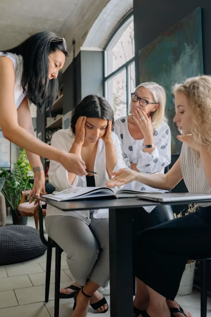 woman at work looking overwhelmed in group of colleagues