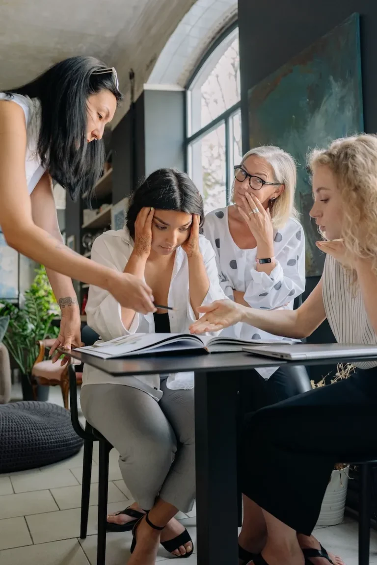 woman at work looking overwhelmed in group of colleagues