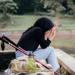 woman on hike sitting with head in hands