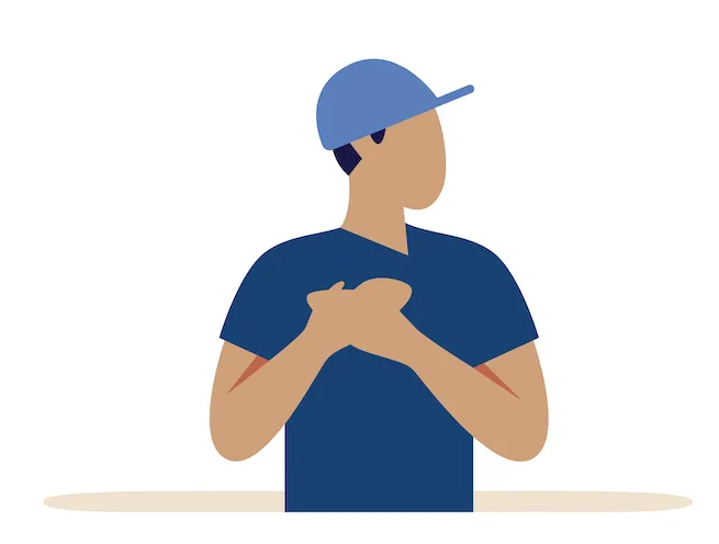 boy with baseball cap and hands over heart