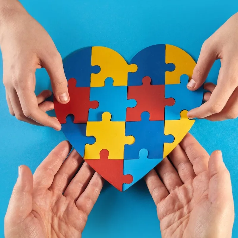hands holding jigsaw shaped like heart