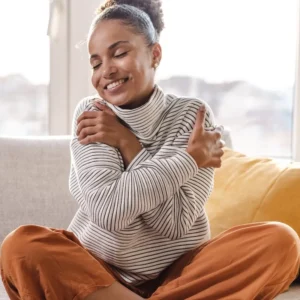 woman giving herself a hug and smiling contently